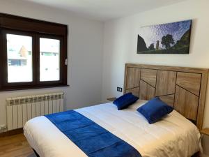 蒙特费雷Cal Canal的一间卧室配有一张带蓝色枕头的大床
