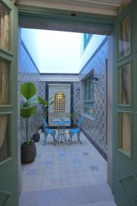 哈马马特Dar Hammamet Guest House & Hammam的天井设有蓝色椅子和桌子。