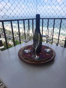 里约热内卢Flat 2 suites com vista para o mar e lagoa.的一张桌子,上面放着两杯酒和一瓶葡萄酒