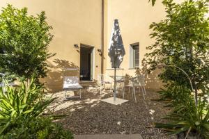 切雷托圭迪Villa Petriolo的庭院配有桌椅和遮阳伞。