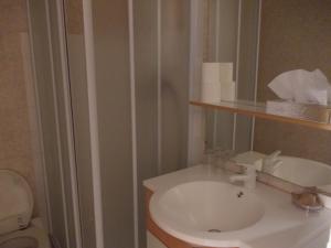 费拉角圣让鲁尔辛酒店的浴室配有白色水槽和卫生间。