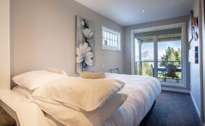 克洛斯本Private Cottage with Spa and Amazing Lake Views的卧室配有一张大白色床和窗户