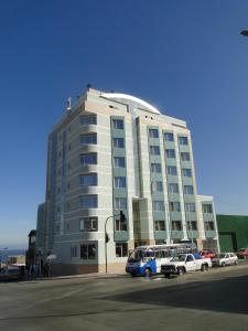 安托法加斯塔Hotel Costa Pacifico - Express的一座白色的大建筑,前面有汽车停放
