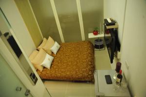 台北宜家居商旅的一间小卧室,配有带枕头的床