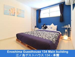 藤泽江之岛134号旅馆的一间卧室配有一张蓝色墙壁的床