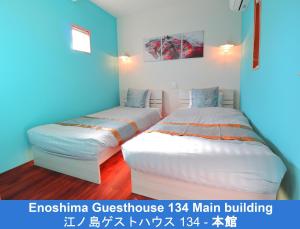 藤泽江之岛134号旅馆的蓝色墙壁客房的两张床