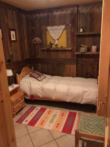 皮拉Fiocco di neve的一间带两张床铺的卧室,位于带木墙的房间内