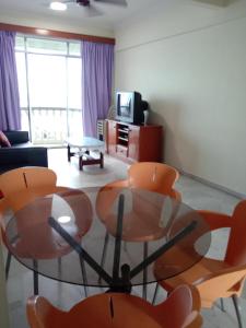 波德申Glory Beach Resort PriVate PentHouse的客厅配有玻璃桌和椅子