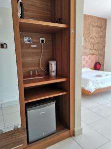 万津Gold Coast Morib Resort的客房设有一个木柜,内配电视