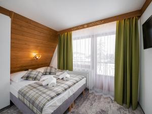 Białka TatrzanskaLeśne Apartamenty的一间卧室配有带2条毛巾的床