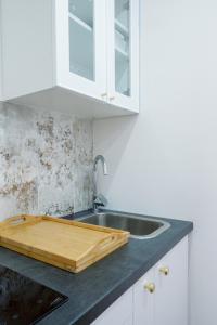 HésingueLa Chambre des Secrets的厨房配有水槽和木制切板