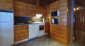 鲁卡Vuosselin Tähti的厨房配有白色家电和木制橱柜
