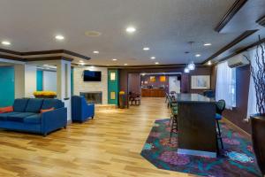 西瓦利城西瓦利康福特茵酒店 - 盐湖城南的客厅设有蓝色的沙发和酒吧。
