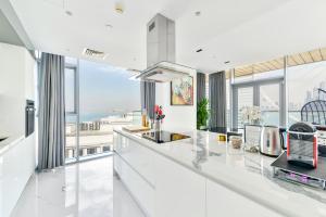 迪拜Luxurious 3 BR w maidroom in BLUEWATERS ISLAND的厨房配有白色的台面和大窗户