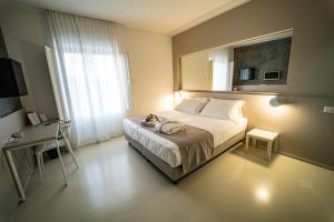马泰拉德尔索凯弗酒店的一间卧室配有一张带镜子和桌子的床