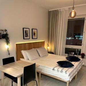 坦佩雷Kaari Home - Studio Apartment In the Heart of Tampere Next to Nokia Arena的一间卧室配有一张大床和一张桌子