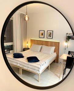 坦佩雷Kaari Home - Studio Apartment In the Heart of Tampere Next to Nokia Arena的一间卧室配有一张带镜子内两个枕头的床