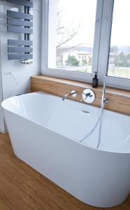 特日内茨Luxury apartment with private sauna Pod Javorovým的带窗户的浴室内的白色浴缸