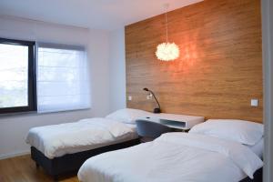 特日内茨Luxury apartment with private sauna Pod Javorovým的一间卧室配有两张床和一张带台灯的桌子