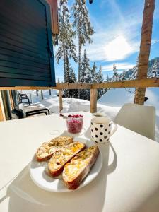 莫济列Sunshine Apartments Golte - Sauna的桌上的一块面包和一杯咖啡
