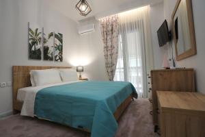 拉里萨LA Larissa Luxury Apartments Stelve的一间卧室配有一张带蓝色毯子的床和窗户。