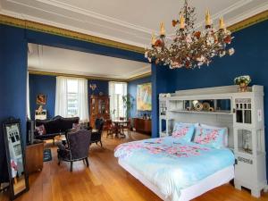 费尔普Villa Dalenstein的一间拥有蓝色墙壁的卧室、一张床和一个吊灯