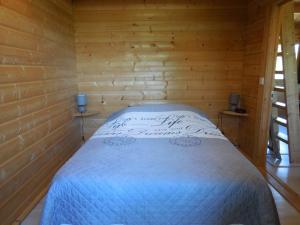 CouxLe chalet bois de Célio的木制客房内的一间卧室,配有一张床