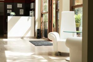 波多诺伏皮拉米德2酒店的客厅配有白色椅子和玻璃桌