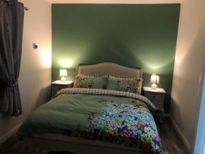 基勒纳德Kearney's Cottage B&B的一间卧室配有一张带绿色墙壁的床
