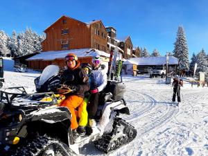 派克波特斯耐兹库Horský hotel Kolínská bouda的一群人骑雪地车在雪地里