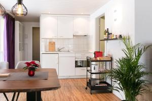 英格堡Spirit Apartments - Balkon - Bergsicht - Parkplatz的厨房配有白色橱柜和木桌