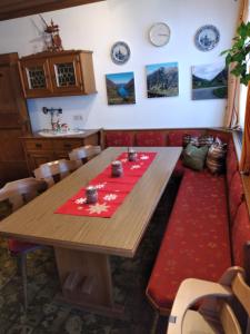 大格洛克纳山道旁富施Bio-Bauernhof Schiederhof的一间设有木桌和红色地毯的用餐室