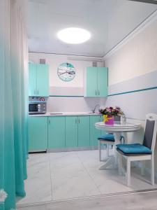 第聂伯罗Апартаменти завжди зі світлом的厨房配有蓝色橱柜和白色桌子