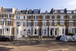 伦敦Luxurious 1-Bedroom Apartment in Kensington的一座大型建筑,设有白色门窗