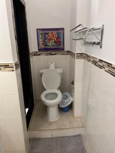 多伦多Adas Guesthouse的浴室设有卫生间,墙上挂有绘画作品