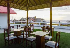 蒙塔尼塔Hotel Sol y Playa Montañita的阳台餐厅,配有桌椅
