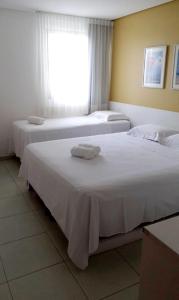 塔曼达雷Carneiros Beach Resort - Apto 214D的两张位于酒店客房的床,配有毛巾