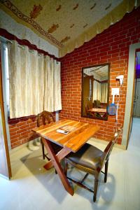 斋浦尔Amrit Van Resort的砖墙间里的一张木桌子和椅子