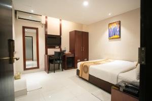达卡Jatra Hotel Grand Royal的配有一张床和一张书桌的酒店客房