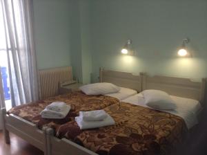 MandrákionHaritos Hotel - Geothermal Hot Swimming Pool的一间卧室配有两张带毛巾的床