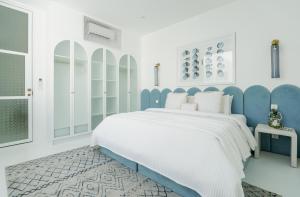 坎古The Cali Villas Canggu的白色和蓝色的卧室设有一张大床