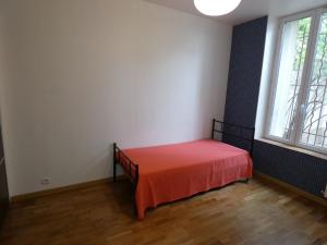 南希Appartement Charmant, quartier calme的一间房间,床上铺有红色床单