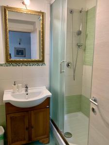 罗马Guest House Casa Vicenza的浴室配有盥洗盆和带镜子的淋浴