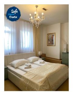 赛斯韦泰Hotel Martini Zagreb Hotel and Restaurant的卧室配有一张带吊灯的大型白色床。