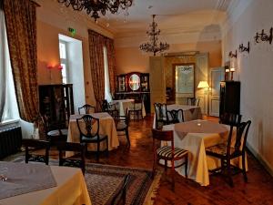 KernuKernu Manor Hotel & SPA的一间在房间内配有桌椅的餐厅