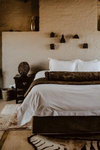 德尔斯特鲁姆African Leaves Trout Lodge的一间卧室配有一张带白色床单和一张桌子的床。