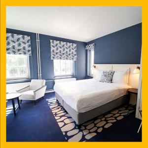 阿尔克马尔The Fallon Hotel Alkmaar的一间卧室配有一张特大号床和一把椅子