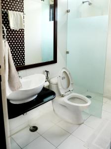新德里因迪旅馆的白色的浴室设有卫生间和水槽。