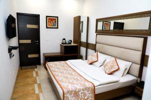 新德里因迪旅馆的一间卧室设有一张床和一个黑色的门