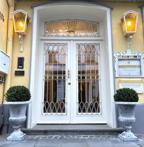 柯尼希斯温特Das Hotel Krone的两棵植物的建筑上的白色门